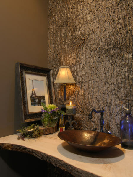 A large authentic tulip poplar bark wall panel adorns a powder room wall, adding 3D texture