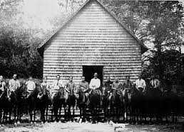 Biltmore Forest School forestry students astride their horses in front of the first forestry schoolhouse in America